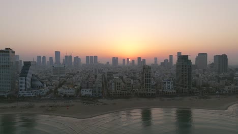 tel aviv coastline at sunrise with beautiful calm waters of the mediterranean sea, waterfront hotels and light sun flare