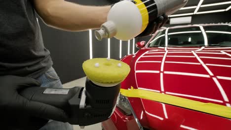 worker polish a red car. car detailing - men are using machinery car polishers maintenance to remove marks repair according to the surface of the car's paint before contin