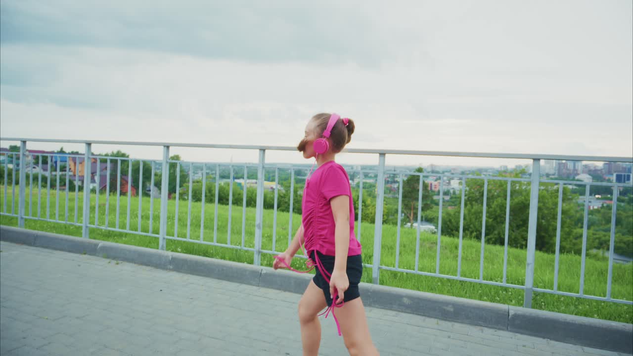 A Young Girl Enjoys Her Music While Dancing and Exercising Outdoors, Captured in Two Frames Showcasing Her Joyful Movement and Enthusiasm