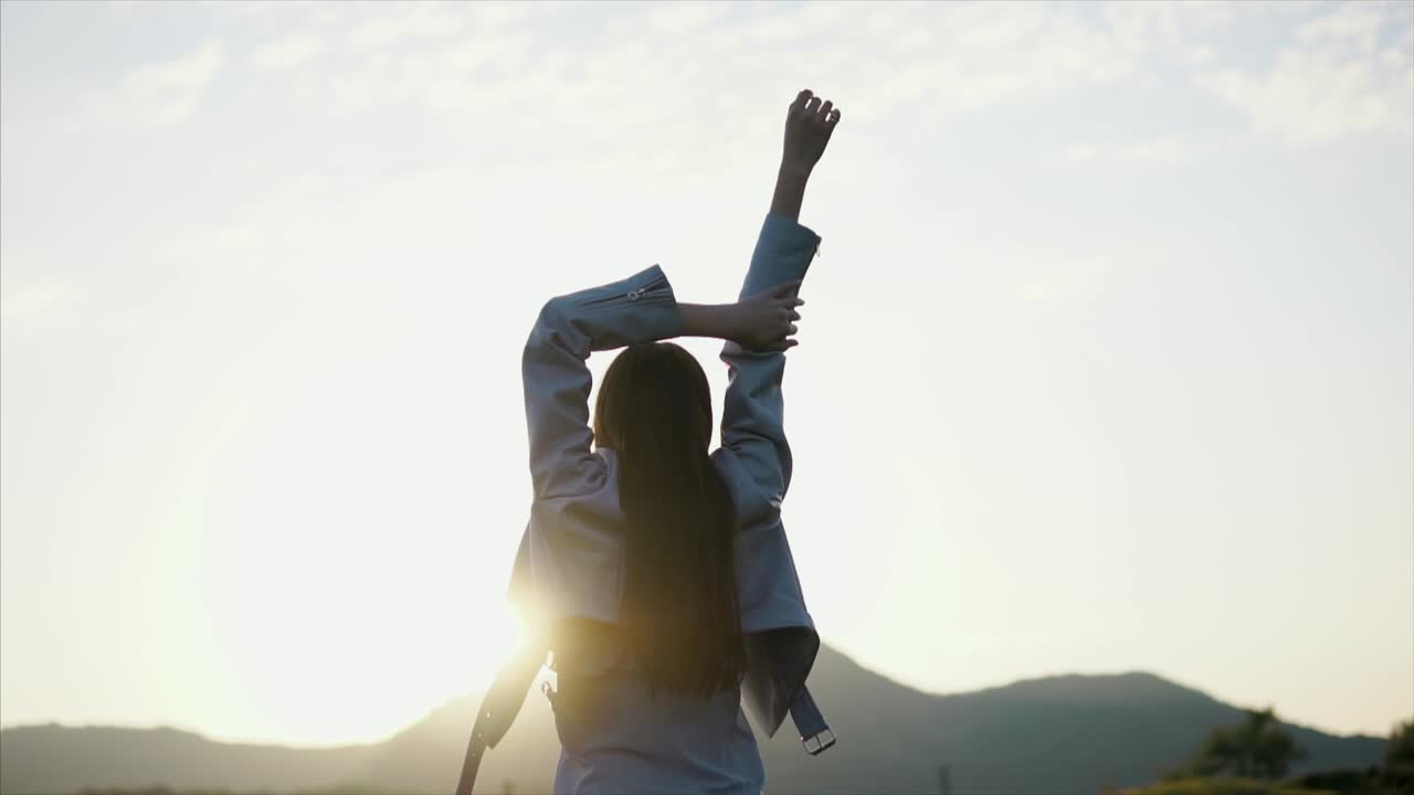 mujer disfrutando de la puesta de sol en la plantación de té