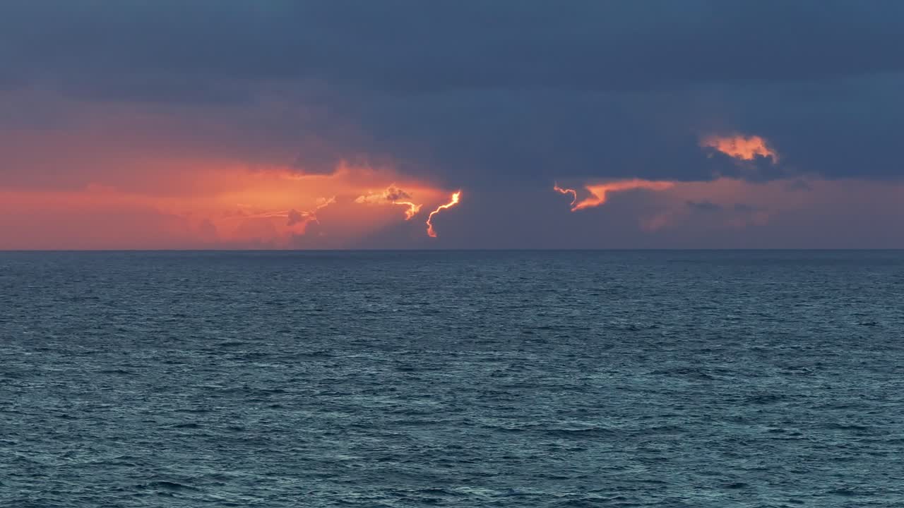 Slowmotion wide drone shot of big ocean waves and cloudy sunset
