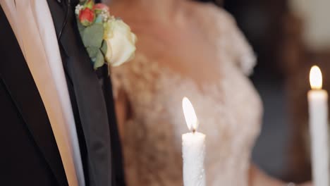 newlyweds. bride and the groom stand in church, holding candles in their hands