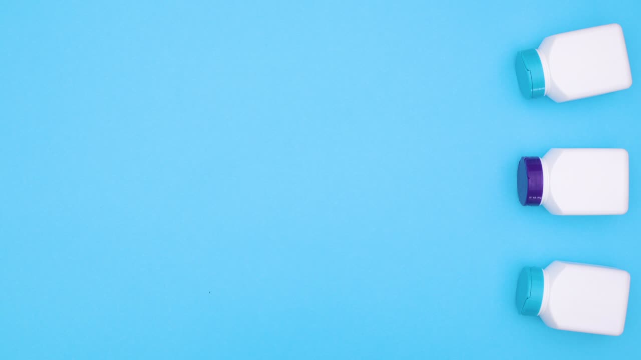 Pílulas saindo de frascos de remédios de plástico em tema azul. Stop motion