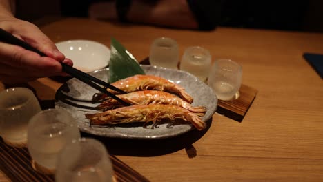 hands serving and plating a shrimp dish