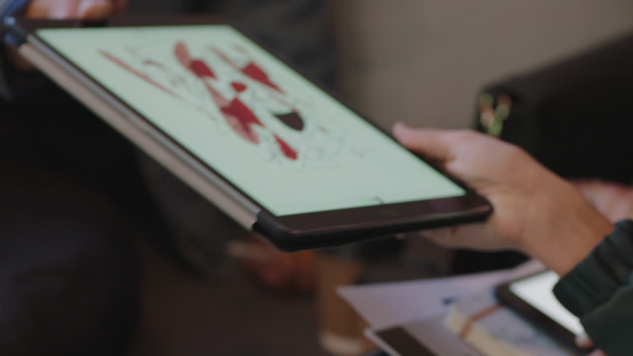 close up hands graphic design students using digital tablet computer sharing design drawing brainstorming creative ideas on mobile device screen