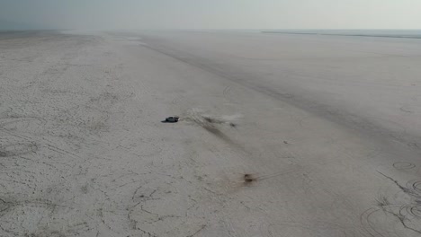 drone rotates around white pickup truck parked bonneville salt flats golden hour