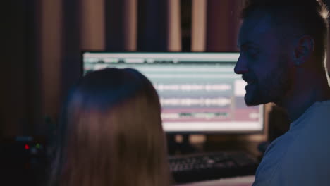 a man and woman work on a music project in a recording studio