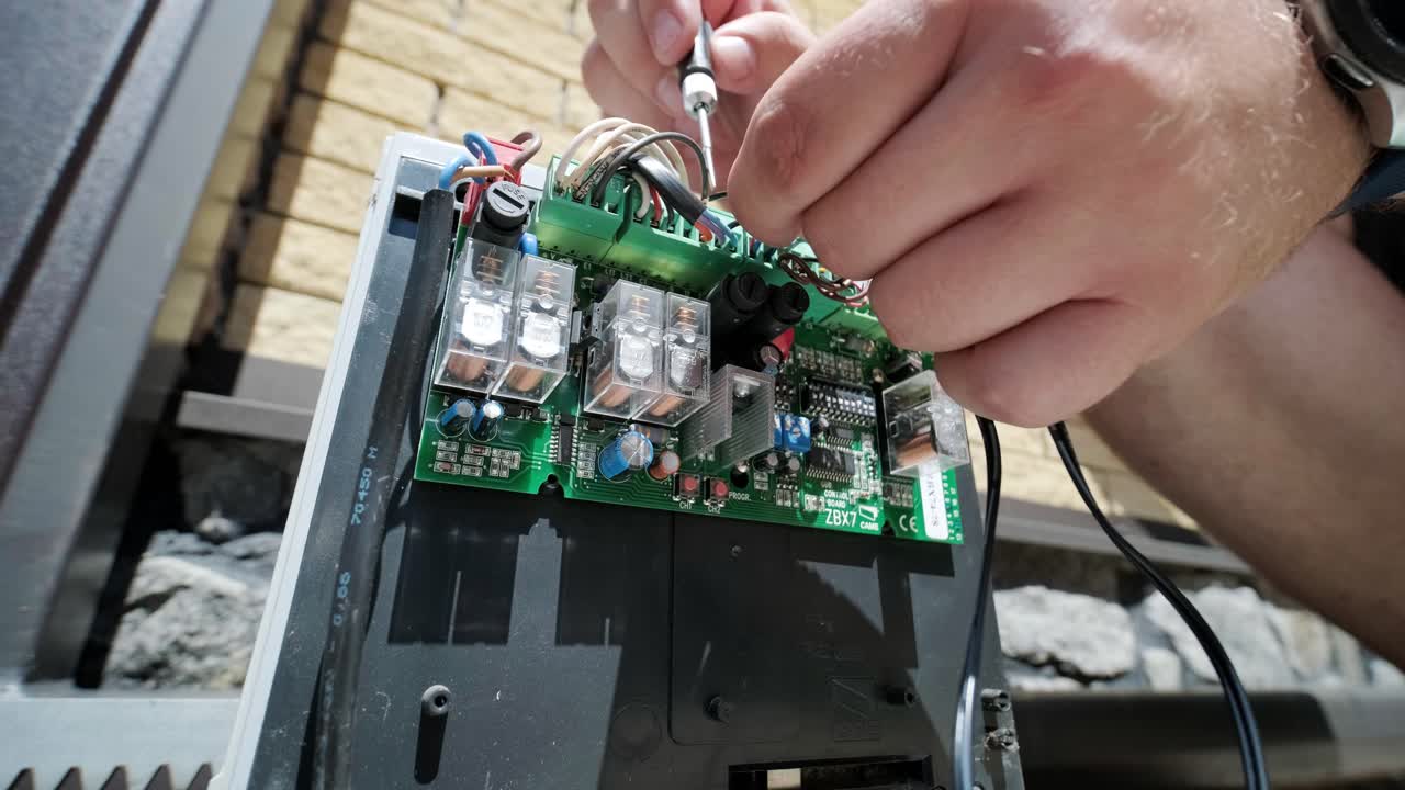 자동 차고 게이트 메커니즘을 원격 컨트롤러와 연결하고 자동 게이트 모터 설치 및 컨트롤 게이트 가정 보안 시스템에 대한 작업