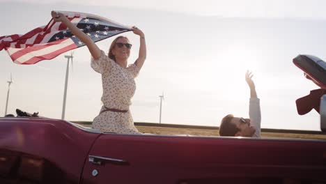 Video-Einer-Frau,-Die-Ein-Auto-Mit-Amerikanischer-Flagge-Fährt