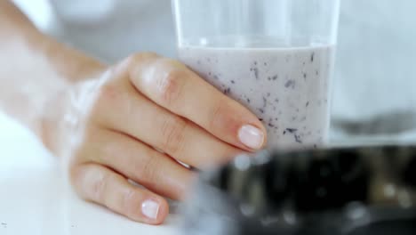 Woman-pouring-smoothie-in-glass