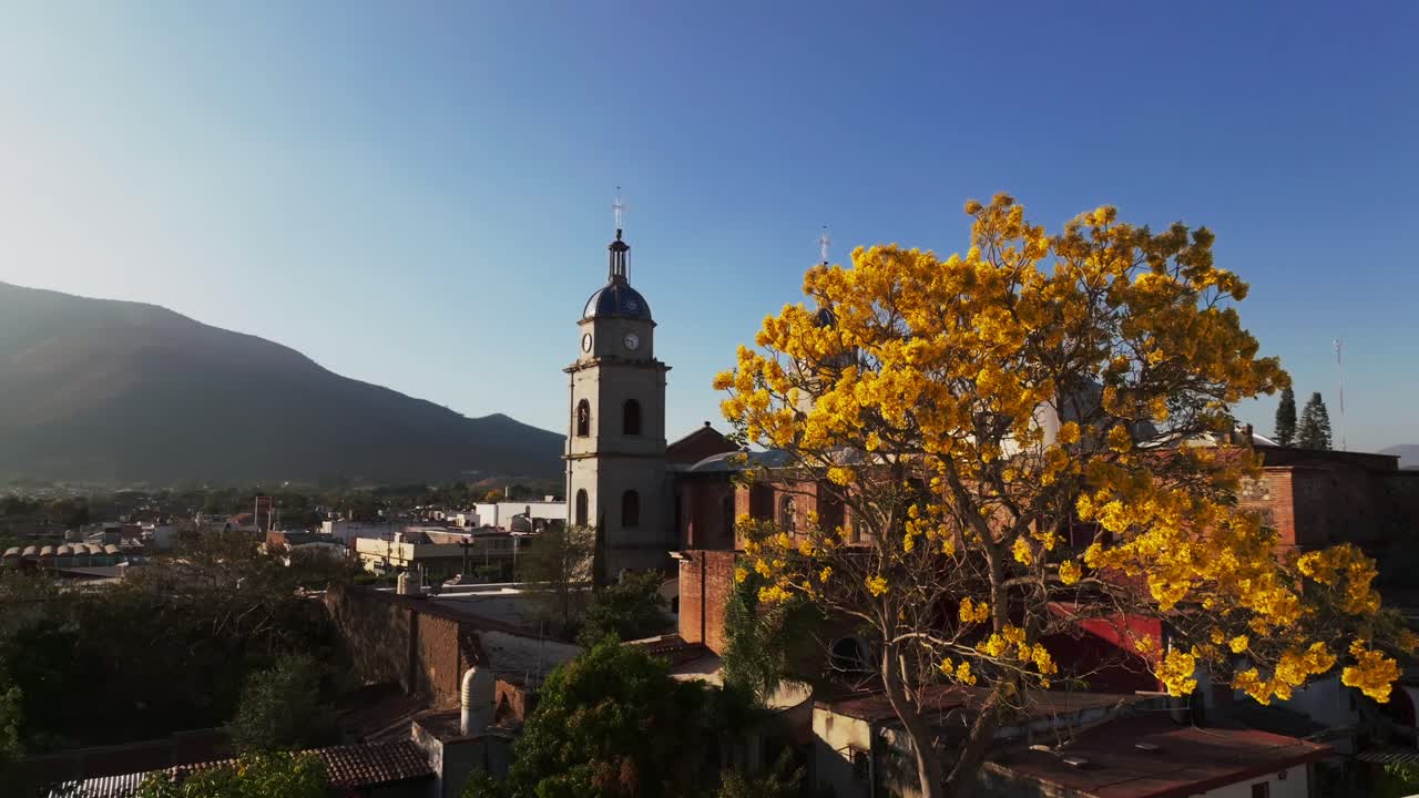 fotografía aérea que muestra la popular atracción turística del templo de san bautista en tuxpan durante la puesta de sol dorada: silueta de la montaña en el fondo