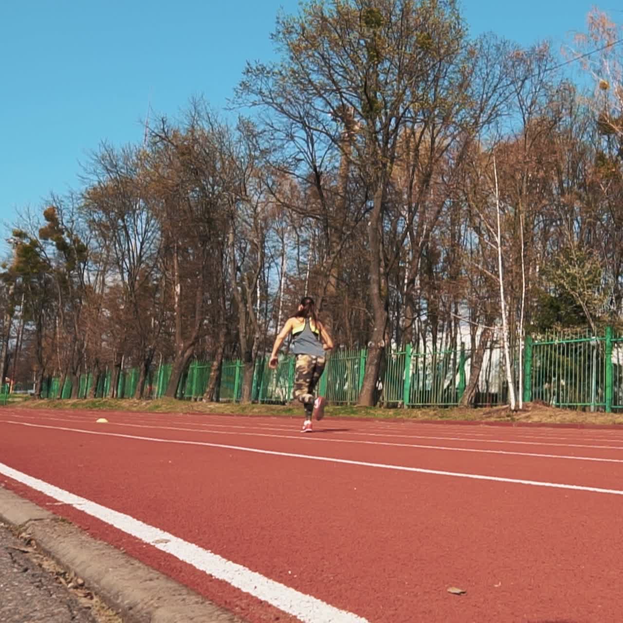 Summer outdoors training. Athletic woman running on track. Beautiful body.