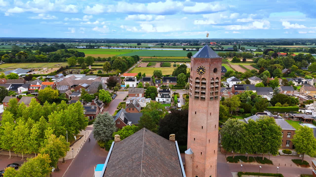 Rising along the tower of the Laurentiuskerk in Vierlingsbeek, Netherlands. Revealing view on the picturesque landscape of the beautiful countryside ta backdrop