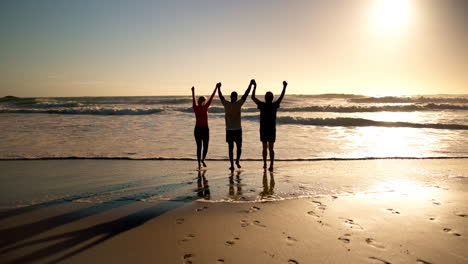 people celebrating on the beach at sunset
