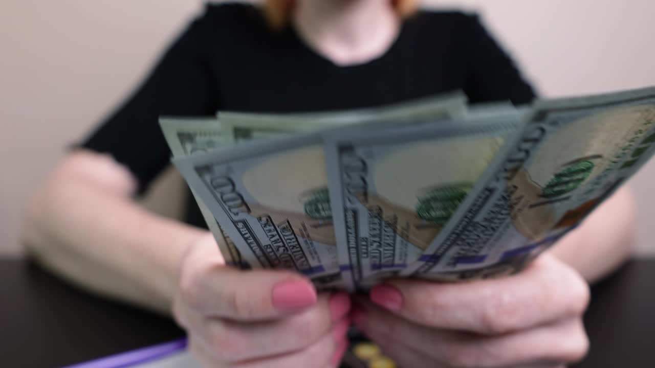 여성의 손에 달러, 소녀는 지폐, 종이 돈을 계산합니다. 가족 예산, 청구서 지불