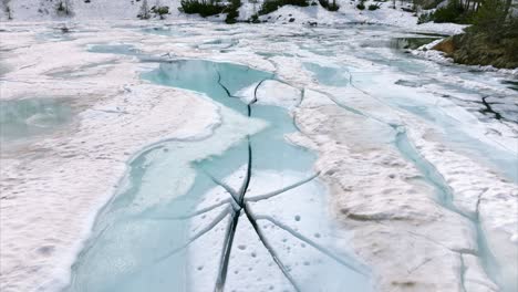 frozen mountain lake with cracks - lago lagazzuolo in valmalenco, lombardy, italy