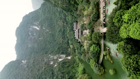 tourist visiting bai dinh buddist pagoda complex and sacred caves in trang an eco-tourism site scenic landscape complex, drone flying over, vertical footage