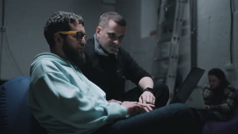 men collaborating on a laptop in a room