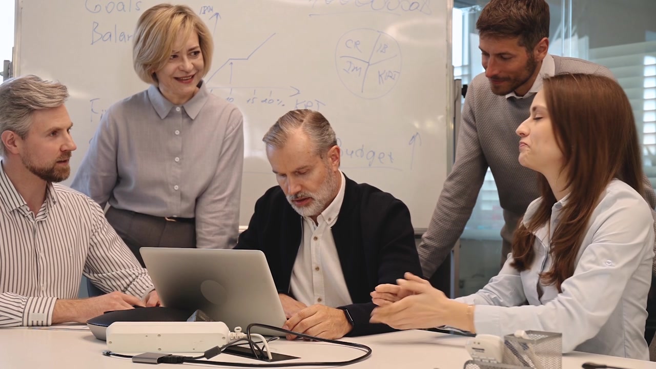 Diverse Business Team Collaborating on Laptop in Modern Office Meeting