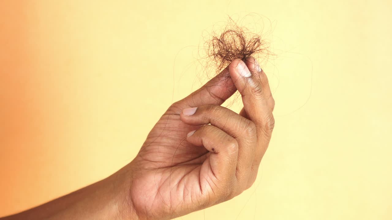 con las manos sosteniendo racimos de pelo