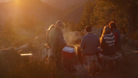 a group of friend stand around a campfire