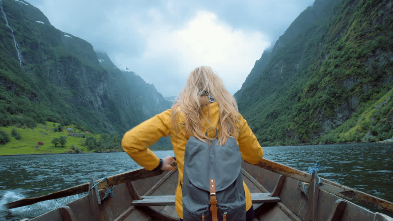 mujer remando un barco en un fiordo