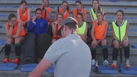 Entrenador-De-Hockey-Explicando-El-Plan-De-Juego-Con-Jugadoras.