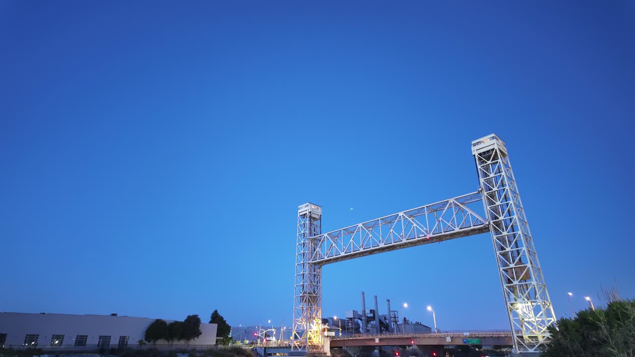 Twilight settles over Alameda as the Miller Sweeney Bridge becomes a corridor of movement, its industrial charm reflected in the water beneath in this evening time-lapse.