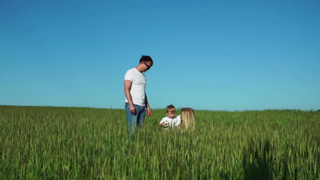 happy family: father mother and son in the field talking and laughing