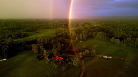 drone shot of a storm brewing over rural farmland with a double rainbow