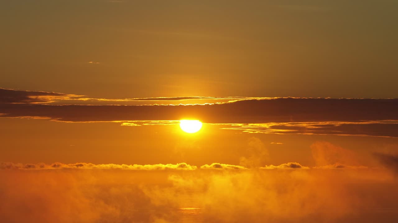 Majestic Golden Sunset Above Clouds with Ocean Reflection