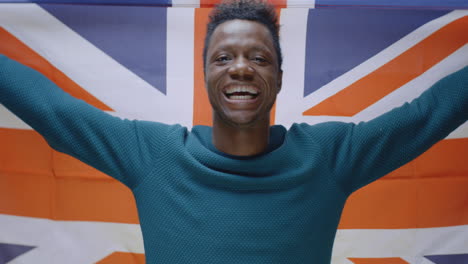 smiling black man holding british flag