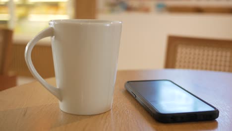 coffee and phone on a table in a cafe