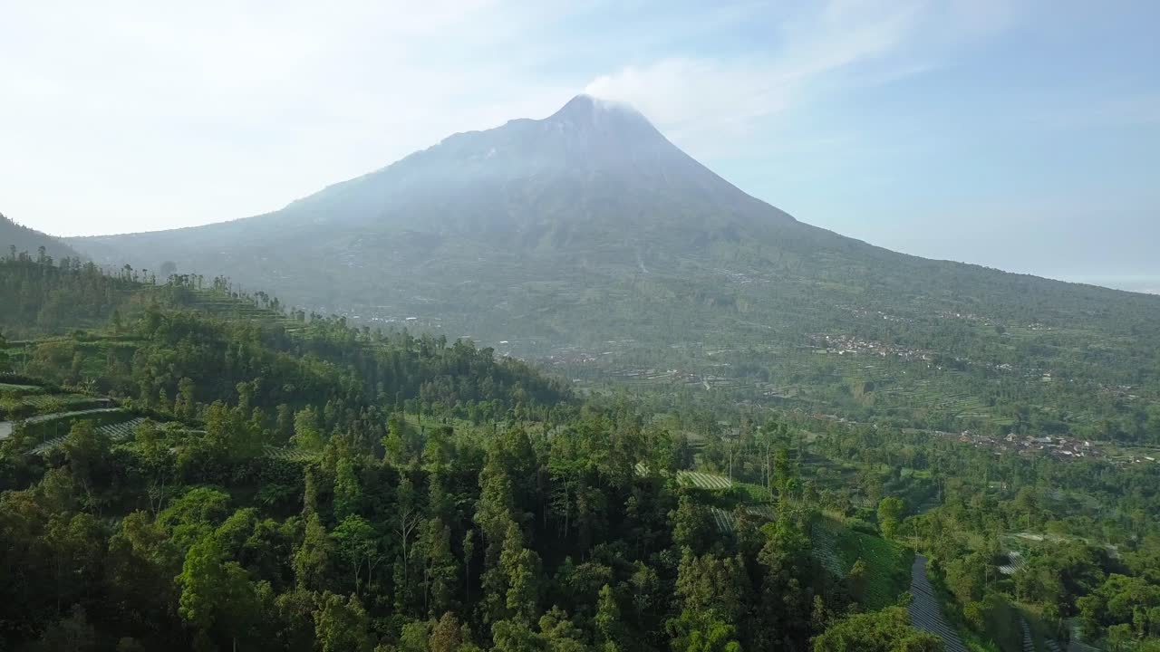Merapi volcano with rural view of plantation that planted with brocolli, cabbage, potatoes and green onions, central java, Indonesia. agricultural industry. 4K aerial view of plantation