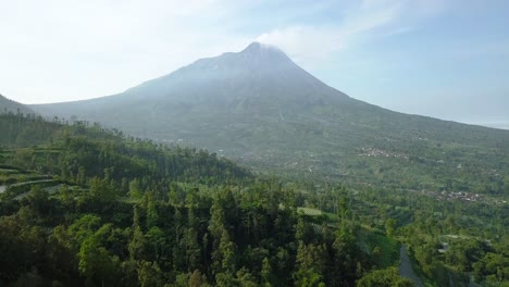 merapi volcano with rural view of plantation that planted with brocolli, cabbage, potatoes and green onions, central java, indonesia. agricultural industry. 4k aerial view of plantation