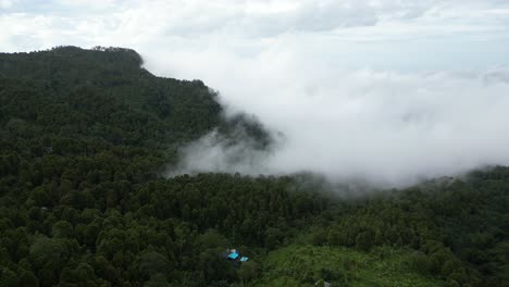 Mountains-covered-in-trees-and-surrounded-by-clouds-in-Bali,-Indonesia