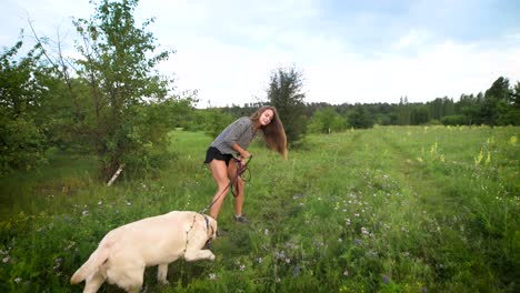 young woman run across the field with a dog