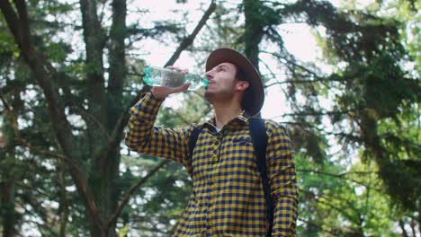 backpacker drinking water in the forest