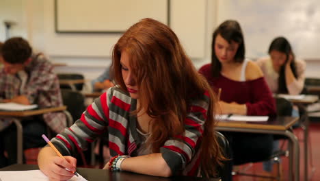 focused students sitting in a classroom and taking notes