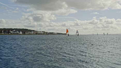 windsurfers at coastal west kirby marine lake enjoying water sports activity on a perfect day