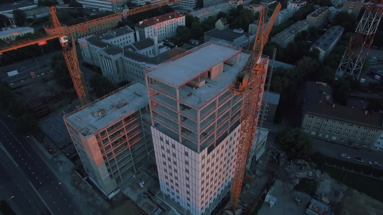 fotografía aérea del edificio del rascacielos en proceso de construcción. en el fondo una grúa de trabajo y una ciudad moderna.