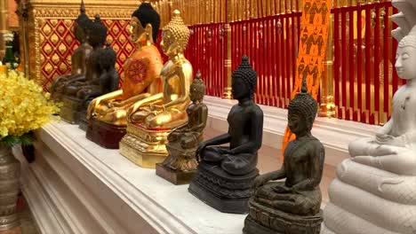 sitting buddha statues in front of temple in thailand