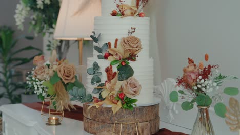 three tier cake adorned with roses berries and rustic floral accents