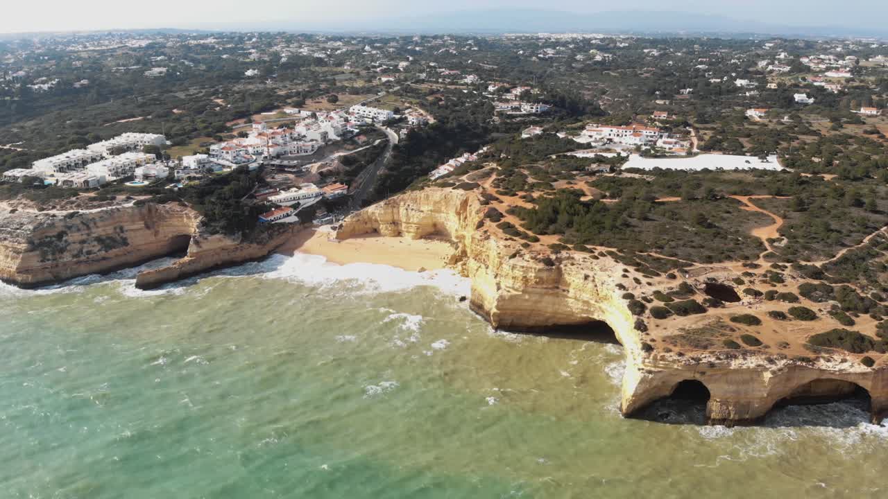 포르투갈 베나길(benagil) 해안 마을 근처의 절벽, 암석 및 해변의 공중 4k 드론 영상 패닝
