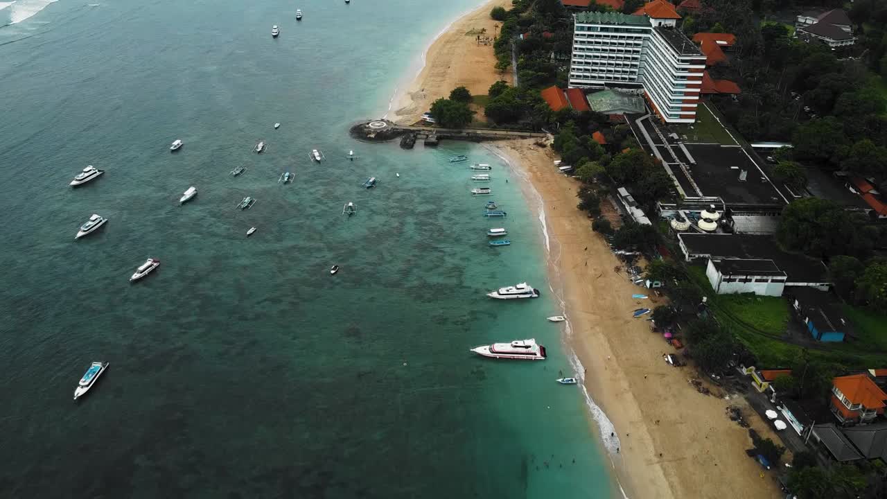 아름다운 영화 사누르 해변, 흥미로운 풍경, 낚시 보트, 호텔, 리조트 및 잔잔한 날씨가 있는 발리 드론 영상