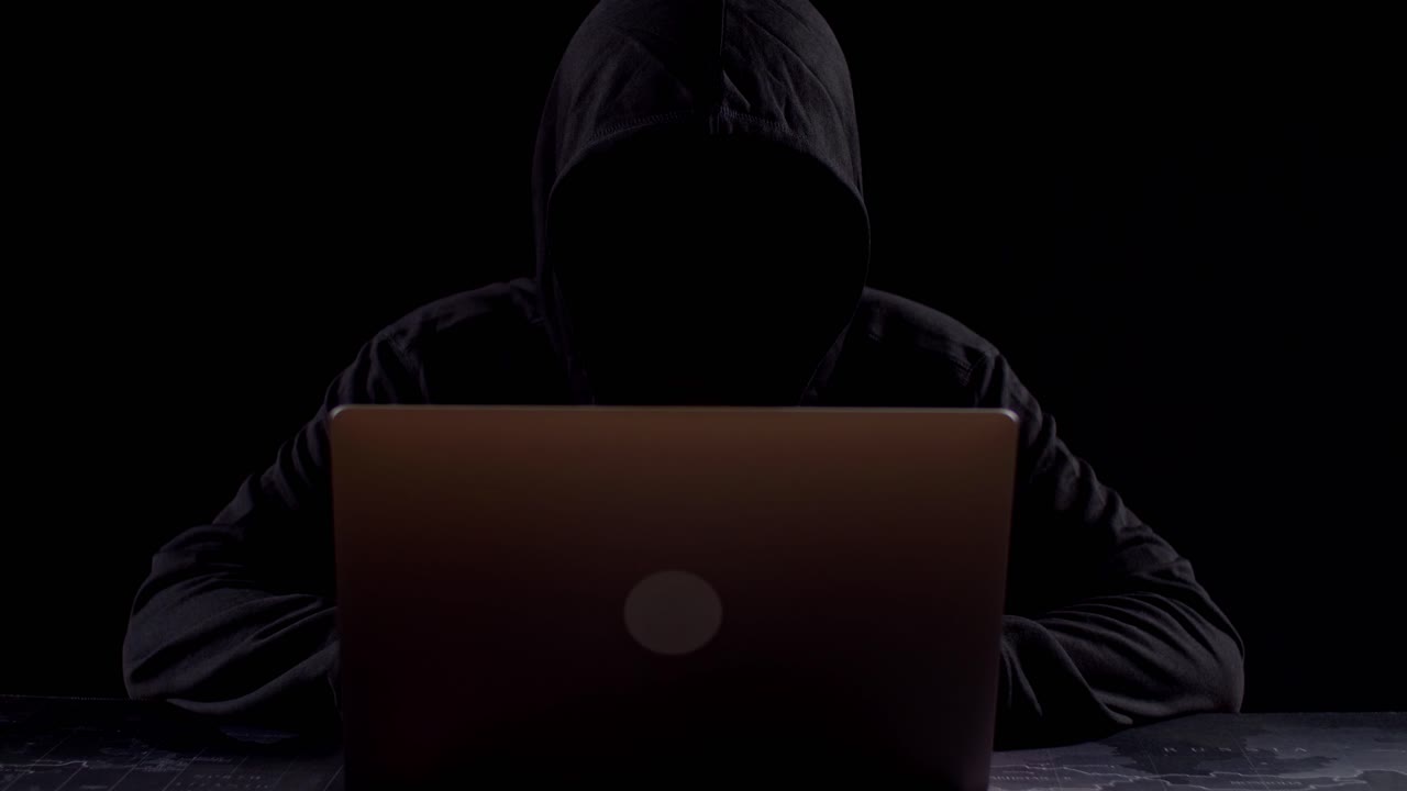 Person Working on Laptop in Dark Room