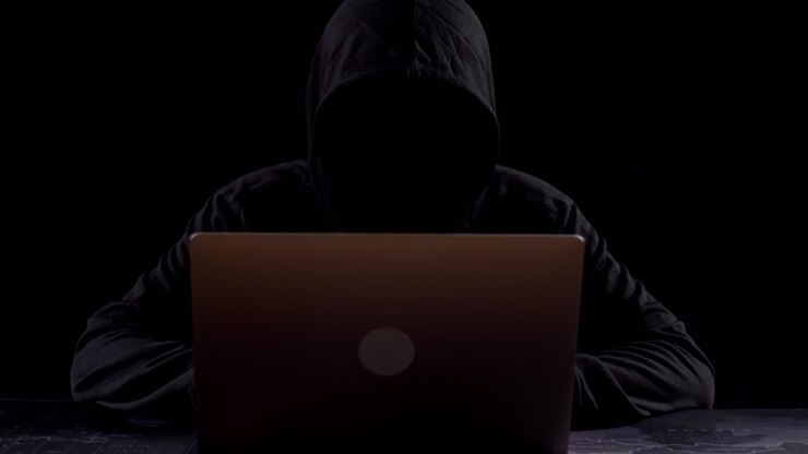 Person arbejder på bærbar computer i mørkt rum