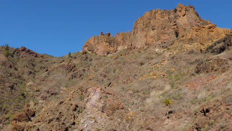 the peak of rockers and motion down on the mountain stony path leading under a mountain in the gran canary island 4k slow motion capture at 60fps