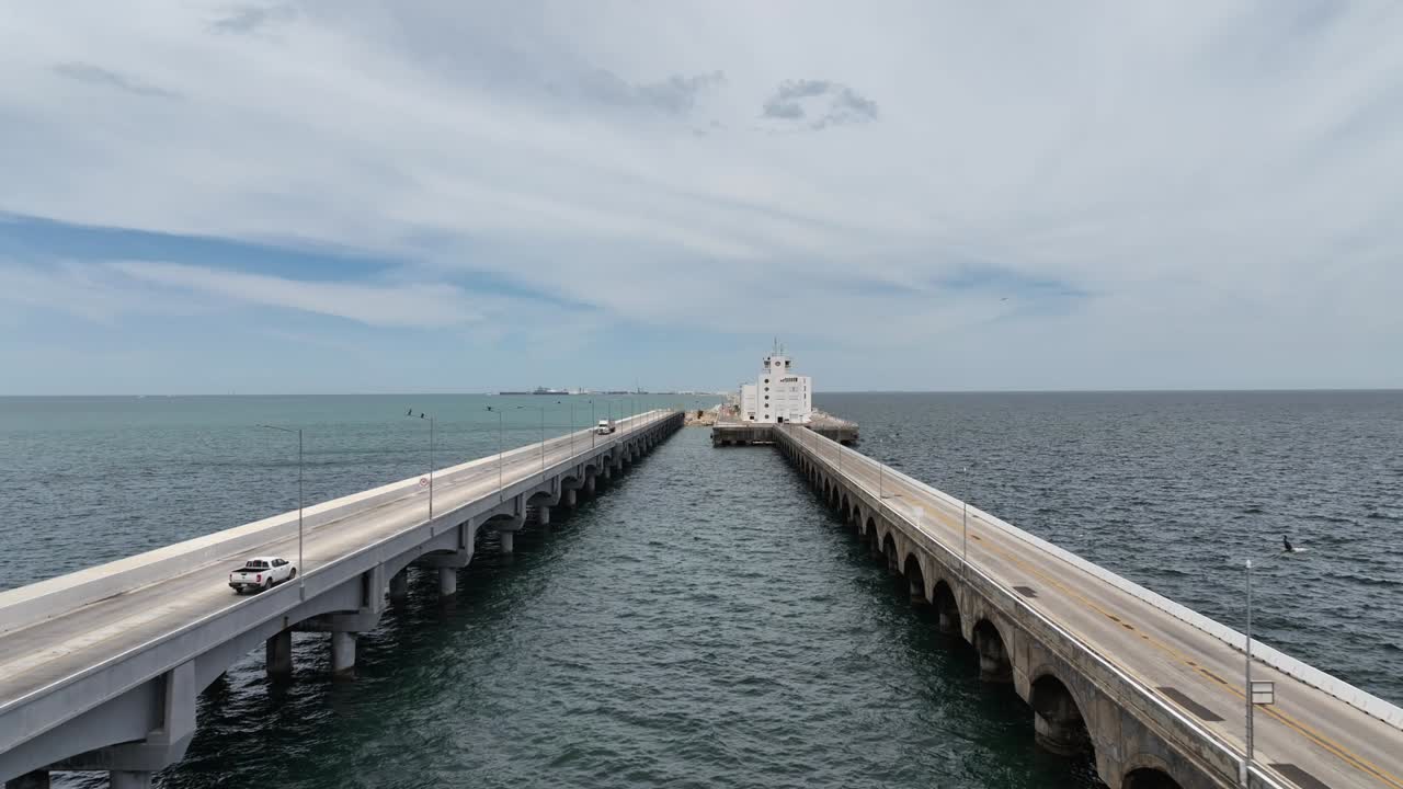 Aerial drone shot, drone flying forward, between the two parallel lanes of the long bridge that connects Progreso, Yucatán to the remote terminal