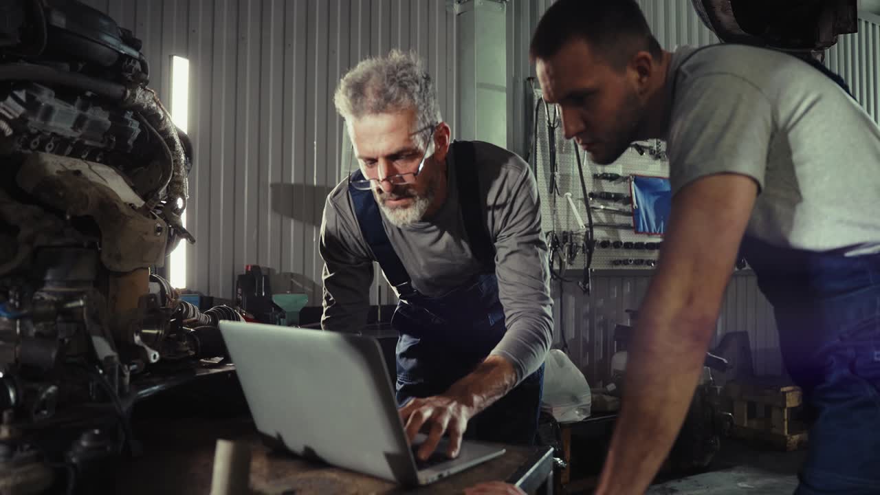 Auto Mechanics Collaborating on Car Repair